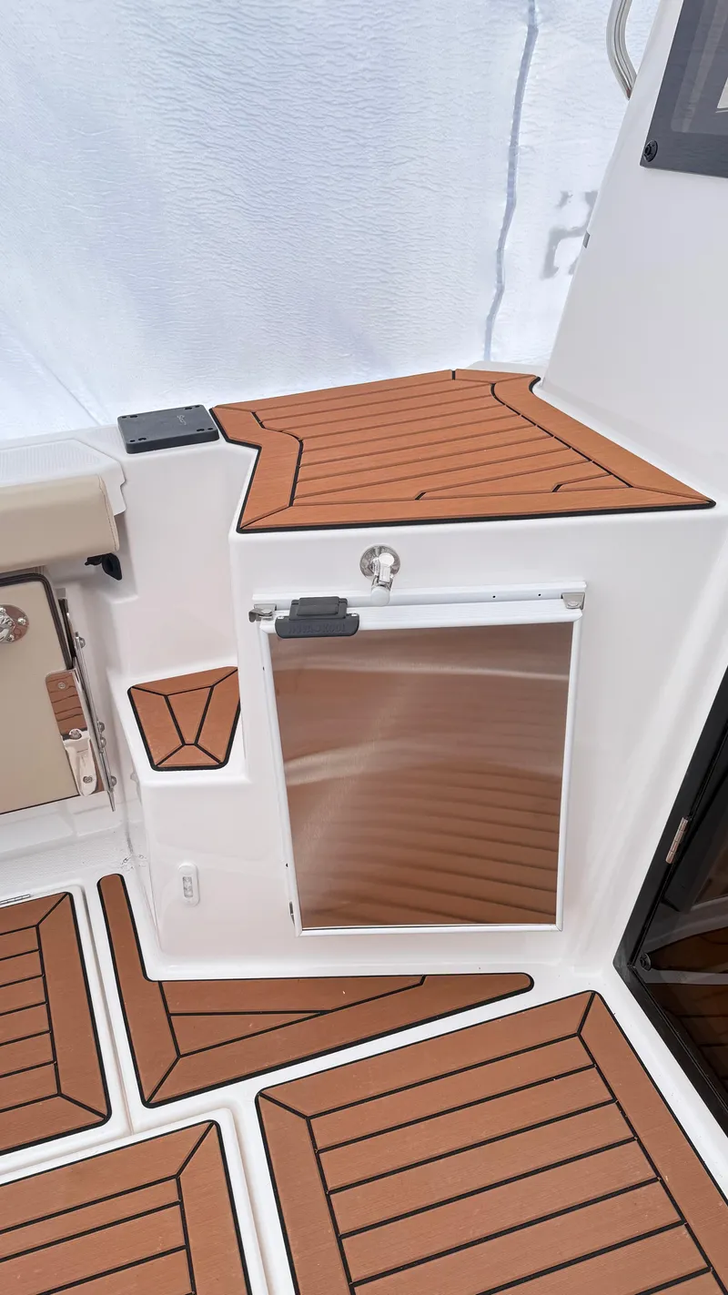 Slide: The Image of 2026 Ranger Tugs R-27 boat interior with wood-patterned flooring and stainless steel features. - 12