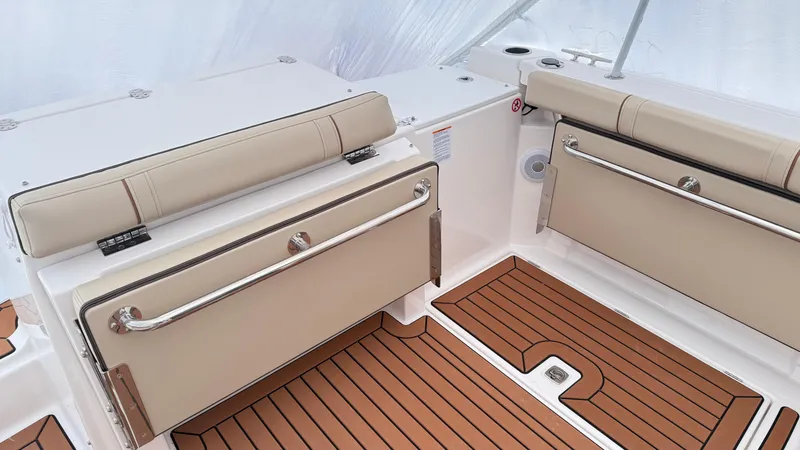 Slide: The Image of 2026 Ranger Tugs R-27 boat interior with beige seating and teak-style flooring. - 13