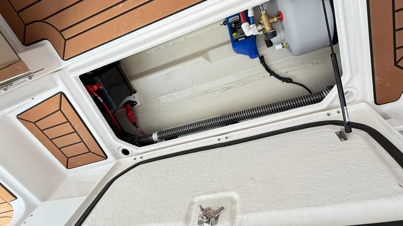 Slide: The Image of 2026 Ranger Tugs R-27 boat storage compartment with electrical and plumbing components. - 20