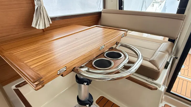 Slide: The Image of 2026 Ranger Tugs R-27 interior with wooden table and cup holders. - 35