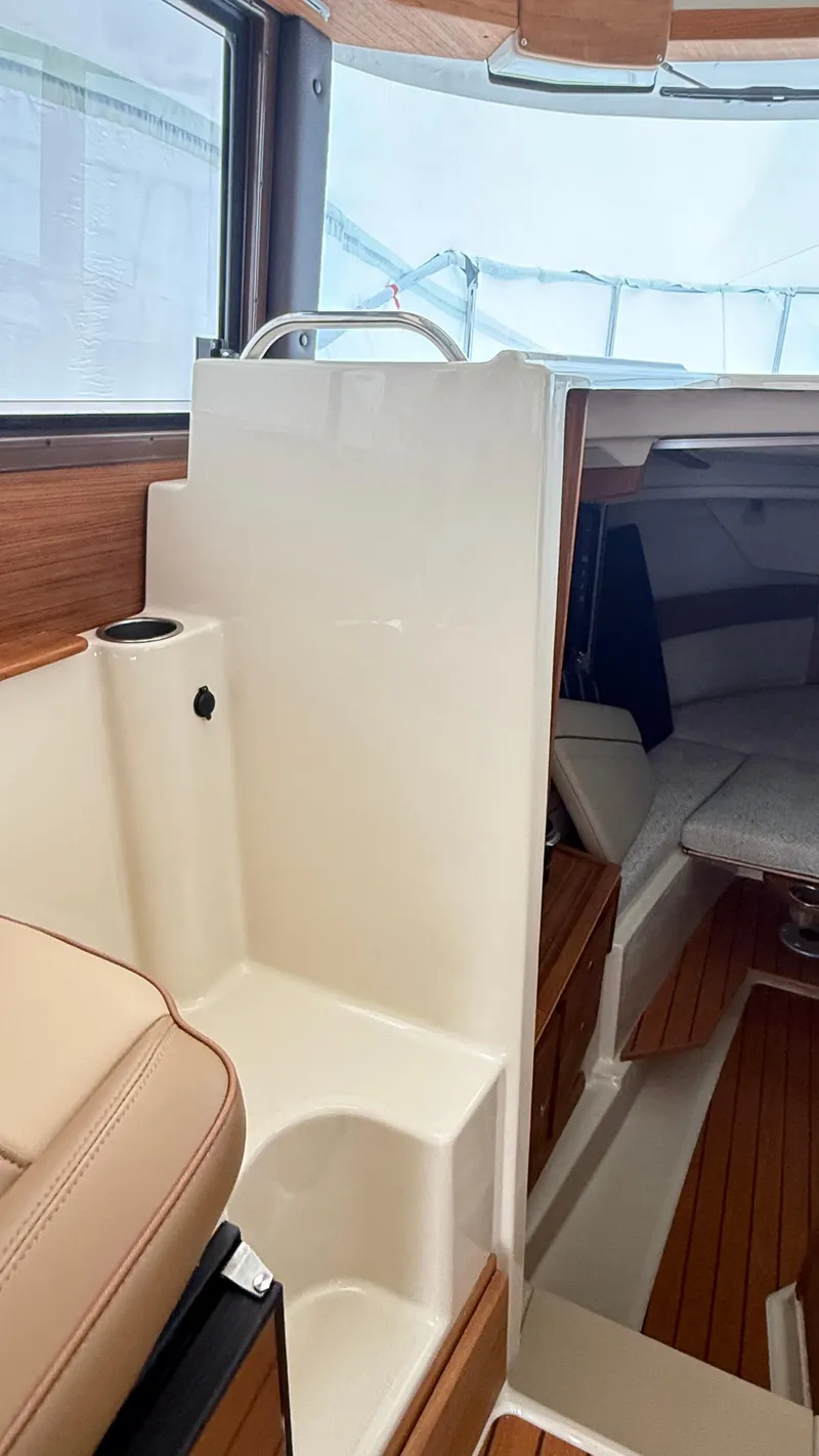 Slide: The Image of Interior of 2026 Ranger Tugs R-27 boat, featuring wood accents and seating area. - 45