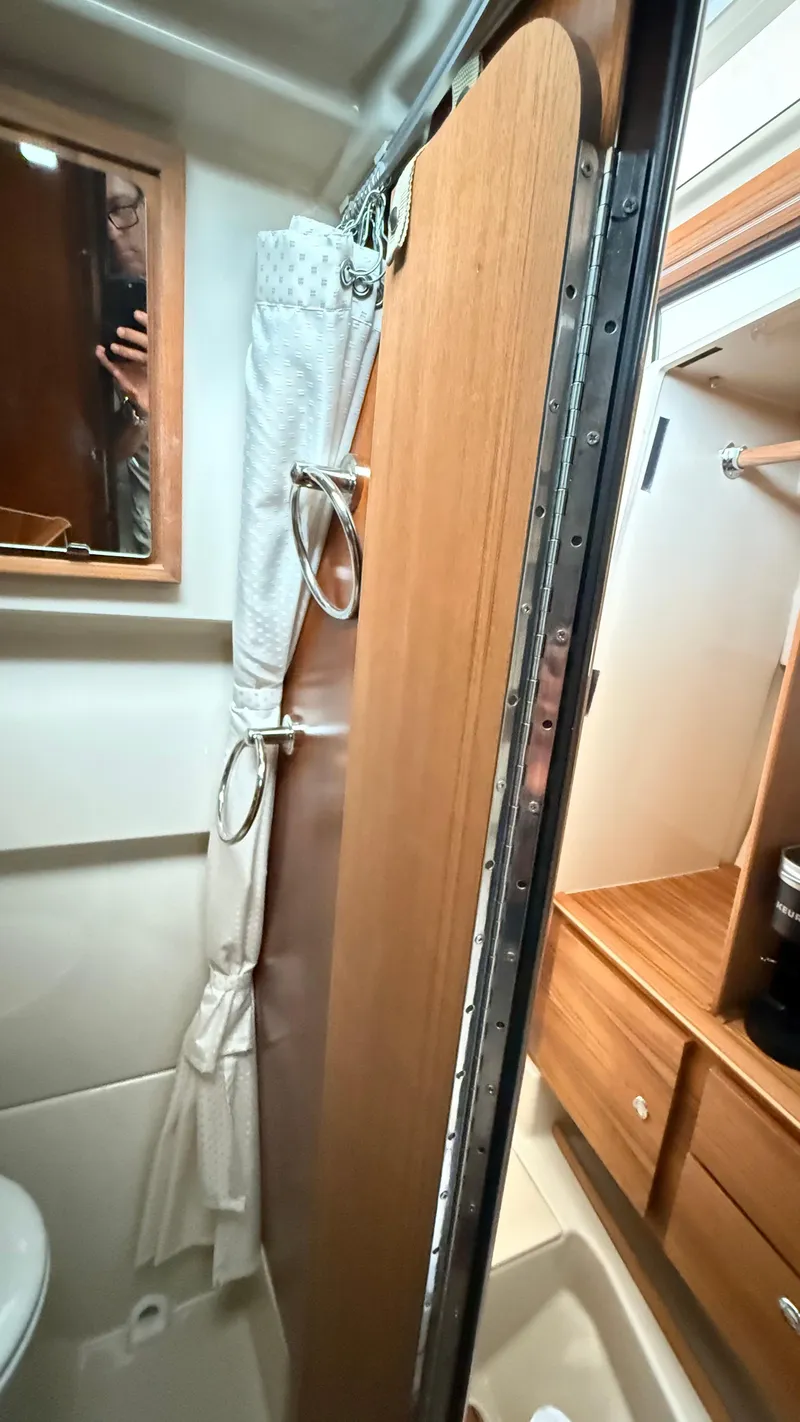 Slide: The Image of Bathroom interior of 2026 Ranger Tugs R-27 with wooden door and mirror. - 54