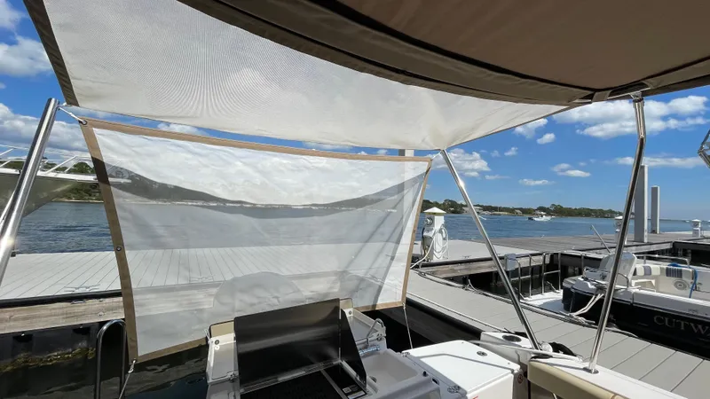 Slide: The Image of 2026 Ranger Tugs R-27 at dock, featuring canopy and scenic waterfront view. - 6