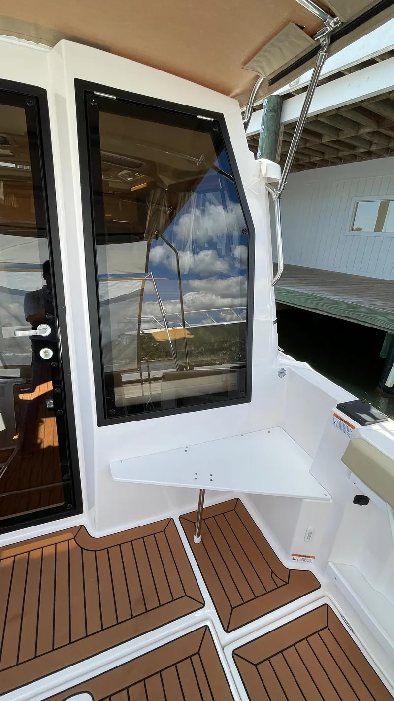 Slide: The Image of 2026 Ranger Tugs R-27 boat interior with wood flooring and large window. - 8