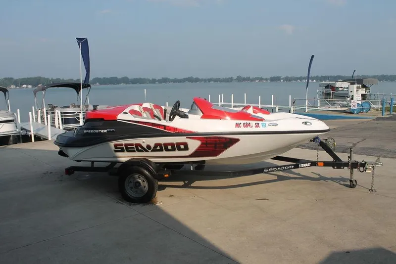 Slide: The Image of 2007 Sea-Doo Speedster 150 boat on trailer by lakeside dock. - 6