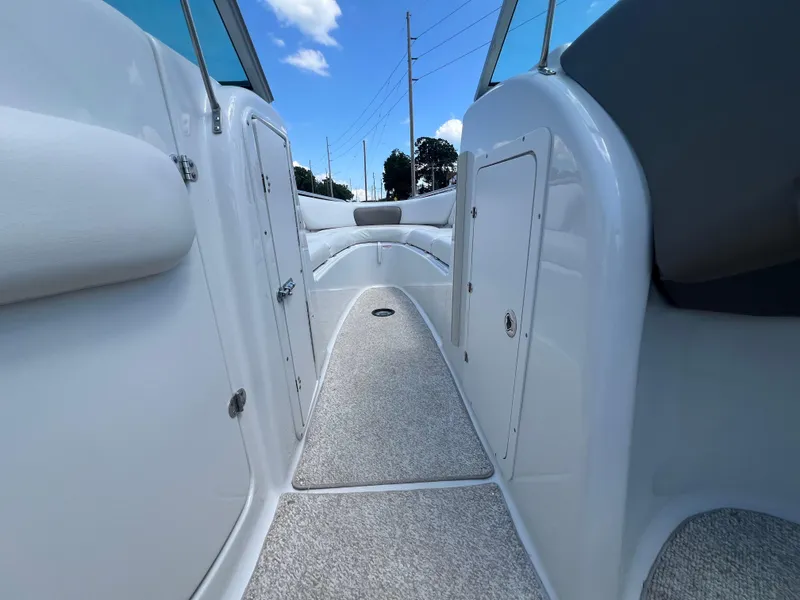 Slide: The Image of 2006 Crownline 270 BR boat interior with carpeted walkway and seating. - 10