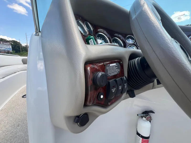 Slide: The Image of 2006 Crownline 270 BR boat dashboard with steering wheel and control switches. - 13
