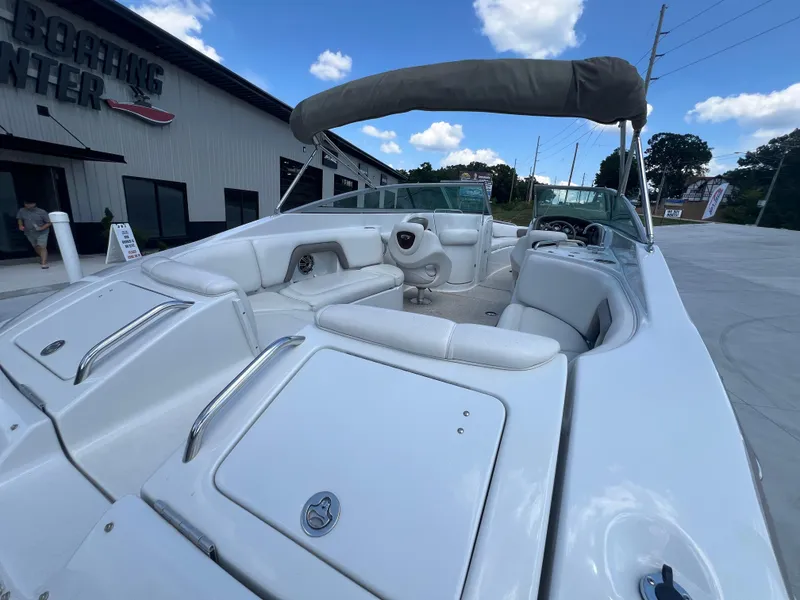 Slide: The Image of 2006 Crownline 270 BR boat with white interior, parked near a boating center. - 22