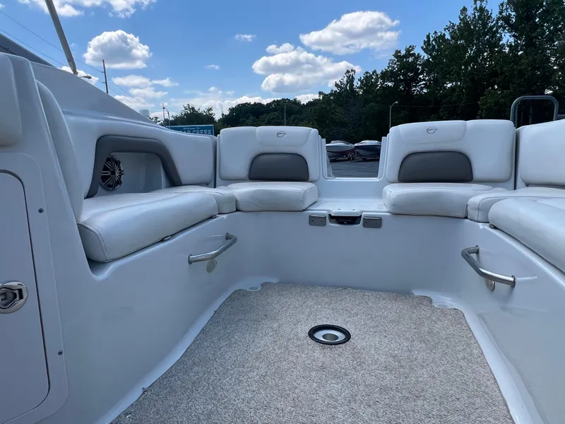 Slide: The Image of 2006 Crownline 270 BR boat interior with white seating and carpeted floor under a blue sky. - 23