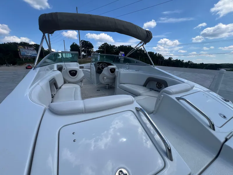 Slide: The Image of 2006 Crownline 270 BR boat with spacious seating and canopy under a blue sky. - 24