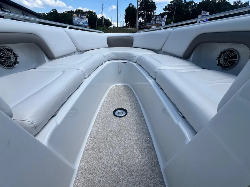 Slide: The Image of 2006 Crownline 270 BR boat interior with white cushioned seating and speakers. - 7