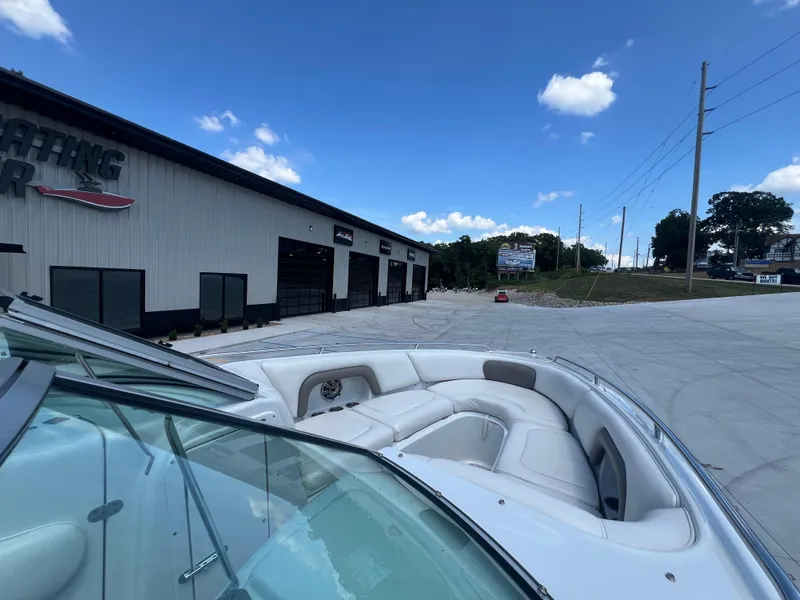 Slide: The Image of 2006 Crownline 270 BR boat parked outside a marine dealership under a clear blue sky. - 8