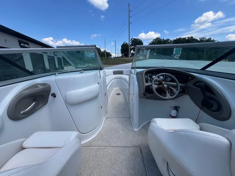 Slide: The Image of 2006 Crownline 270 BR boat interior with steering wheel and seating, under a clear blue sky. - 9