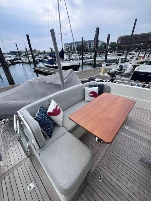 Slide: The Image of 2021 Sabre 45 Salon Express yacht with outdoor seating and wooden table at marina. - 10