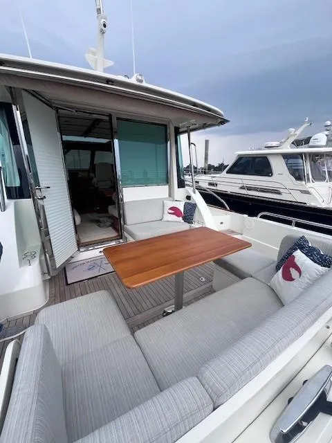Slide: The Image of 2021 Sabre 45 Salon Express yacht with outdoor seating and wooden table. - 11