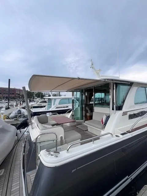 Slide: The Image of 2021 Sabre 45 Salon Express yacht docked at marina, showcasing sleek design and spacious deck. - 12