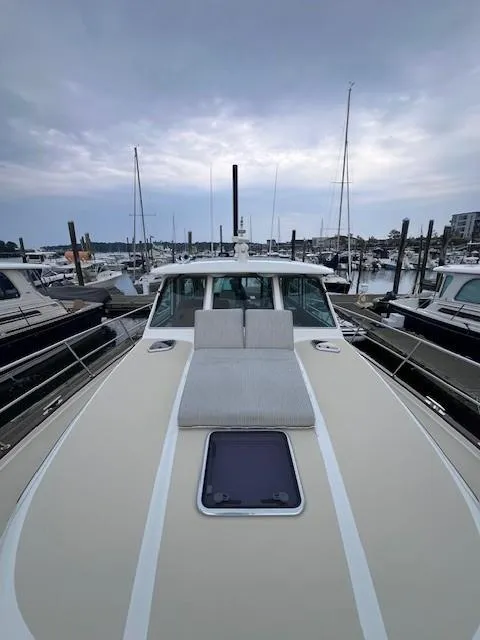Slide: The Image of 2021 Sabre 45 Salon Express yacht docked at marina under cloudy sky. - 16