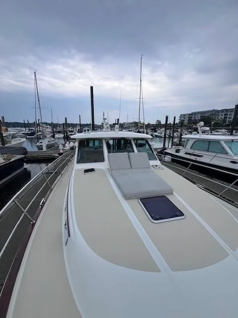 Slide: The Image of 2021 Sabre 45 Salon Express yacht docked at marina under cloudy sky. - 17