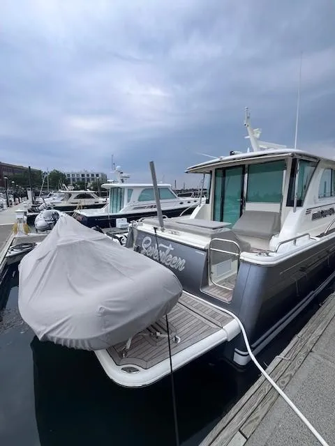 Slide: The Image of 2021 Sabre 45 Salon Express yacht docked at marina under cloudy sky. - 2