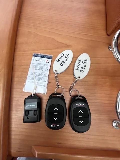 Slide: The Image of Remote controls and key tags on a wooden surface for a 2021 Sabre 45 Salon Express. - 36