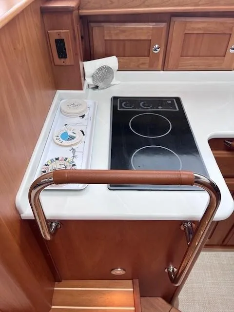 Slide: The Image of 2021 Sabre 45 Salon Express kitchen with electric stove and wooden cabinetry. - 37