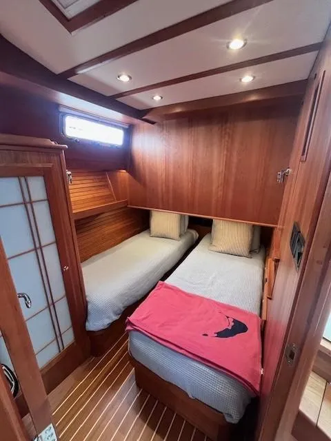 Slide: The Image of 2021 Sabre 45 Salon Express cabin with twin beds, wooden interior, and soft lighting. - 45
