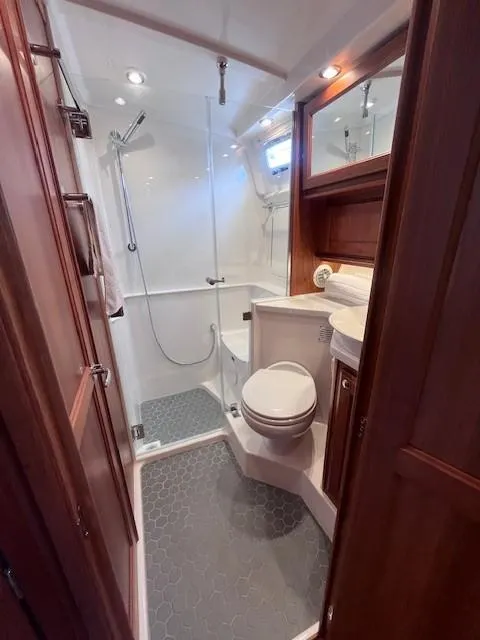 Slide: The Image of 2021 Sabre 45 Salon Express bathroom with shower, toilet, and wooden cabinetry. - 49