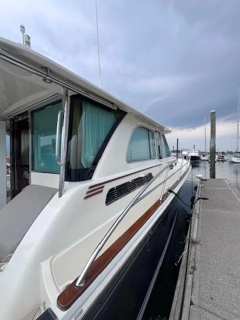 Slide: The Image of 2021 Sabre 45 Salon Express yacht docked at marina under cloudy sky. - 5