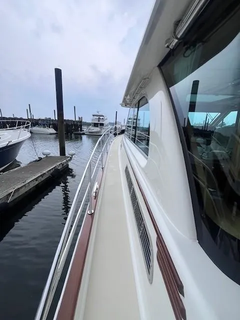 Slide: The Image of 2021 Sabre 45 Salon Express yacht docked at marina, side view with railing and water. - 6