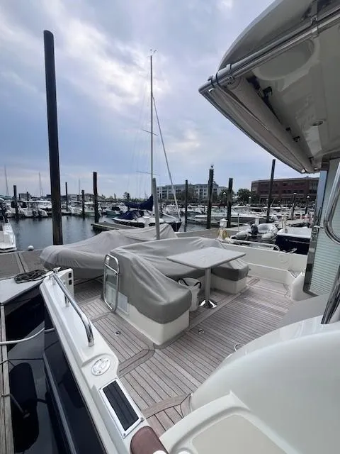 Slide: The Image of 2021 Sabre 45 Salon Express yacht docked at marina, featuring covered seating area. - 7