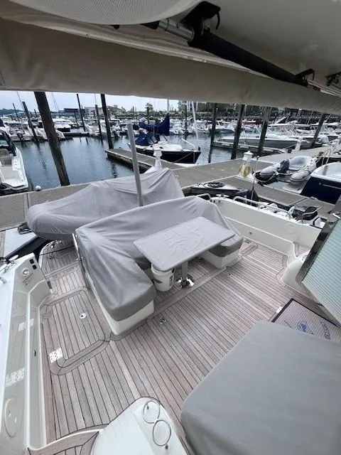 Slide: The Image of 2021 Sabre 45 Salon Express yacht deck with covered seating at marina. - 8