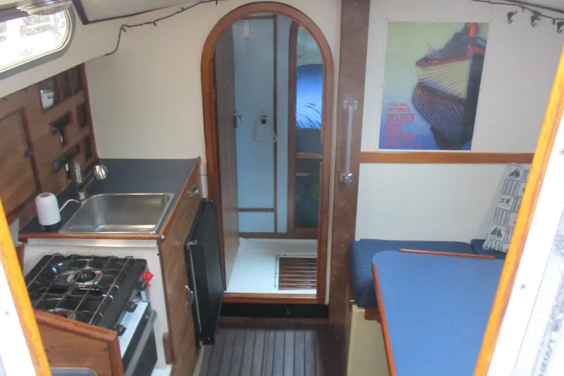 Slide: The Image of 1978 Moody 33 MkI yacht interior with kitchen, seating, and cabin view. - 11