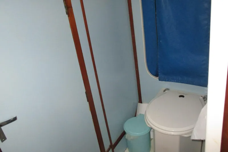Slide: The Image of Small bathroom in a 1978 Moody 33 MkI yacht with blue curtain and toilet. - 12