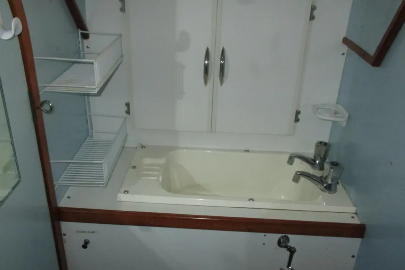 Slide: The Image of 1978 Moody 33 MkI yacht bathroom with sink, faucet, and storage shelves. - 13