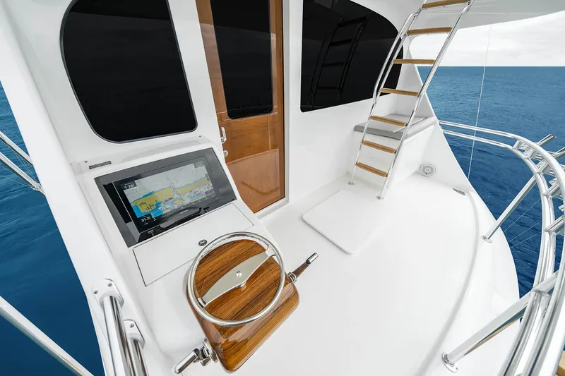 Slide: The Image of Luxurious 2027 Viking 82 Skybridge yacht deck with navigation display and elegant wooden accents. - 22