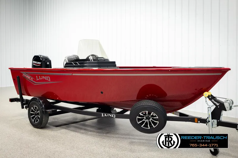 Slide: The Image of 2026 Lund 1650 Rebel XL SS boat in showroom, red exterior, on trailer. - 1