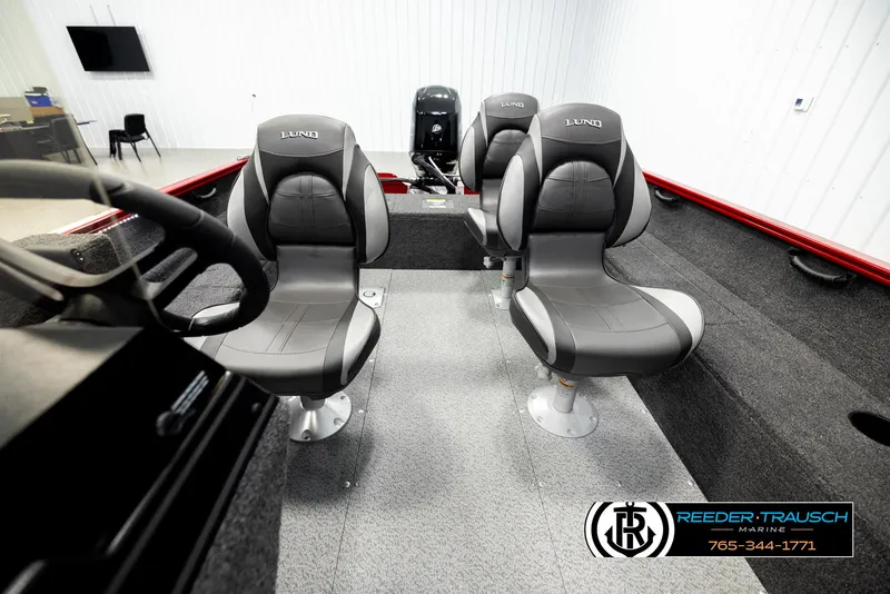 Slide: The Image of 2026 Lund 1650 Rebel XL SS boat interior with four gray seats in a showroom. - 15