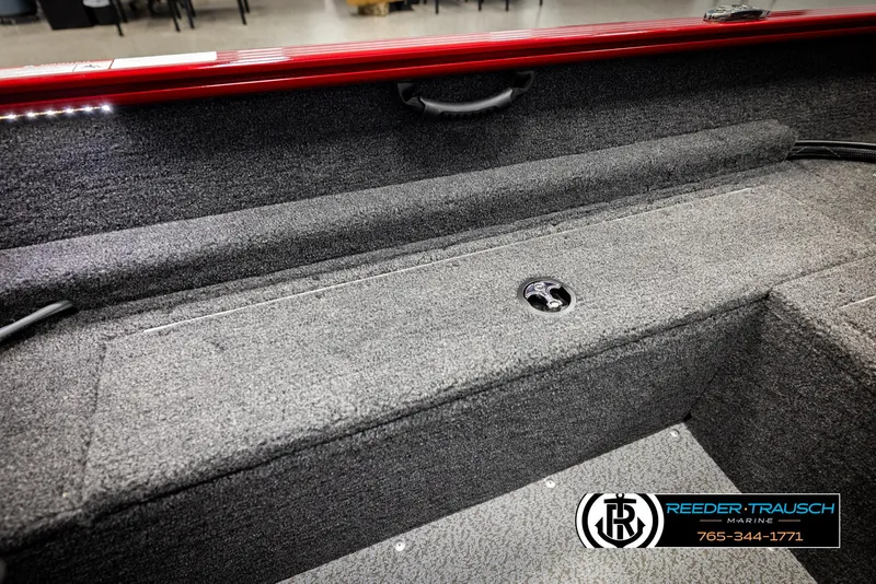 Slide: The Image of 2026 Lund 1650 Rebel XL SS boat interior with gray carpet and storage compartment. - 17