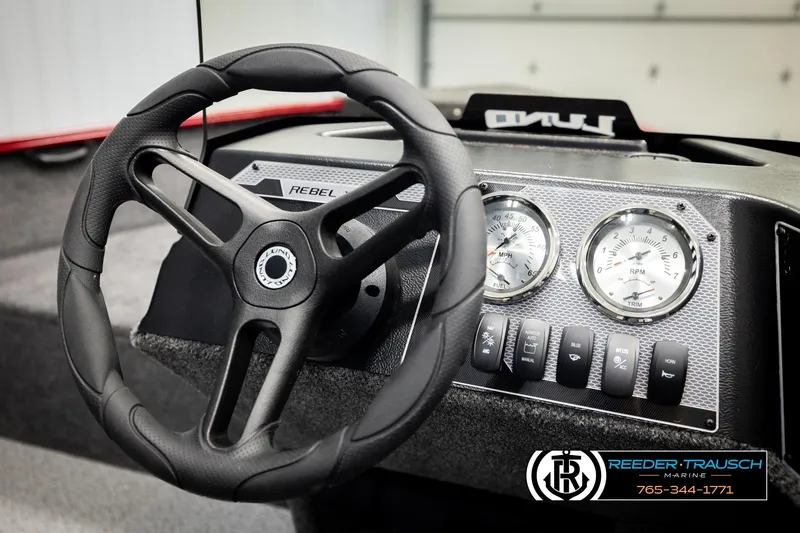 Slide: The Image of 2026 Lund 1650 Rebel XL SS dashboard with steering wheel and gauges, Reeder-Trausch Marine branding. - 27