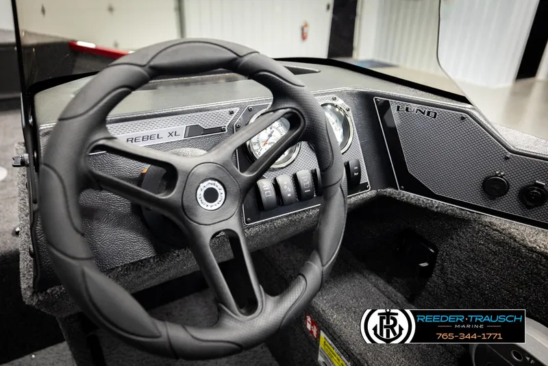 Slide: The Image of 2026 Lund 1650 Rebel XL SS boat dashboard with steering wheel and control panel. - 28