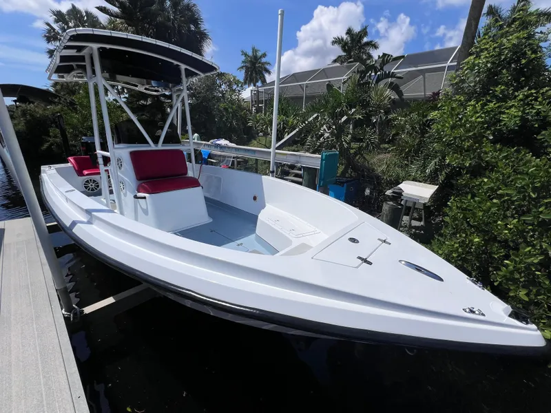 Slide: The Image of White Concept 23 boat from 2000 with red seating, docked near lush greenery. - 11