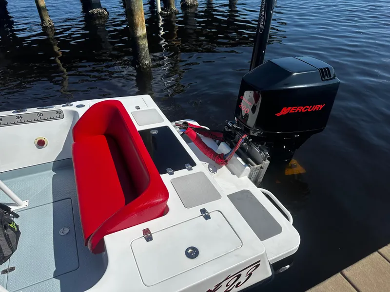 Slide: The Image of Boat with red seating, Mercury outboard motor, Concept 23 model, docked on calm water. - 13