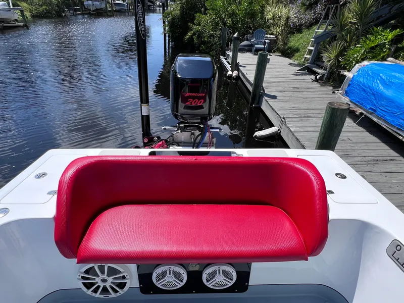 Slide: The Image of Red seat on Concept 23 boat, 2000 model, with outboard motor by a dock. - 15