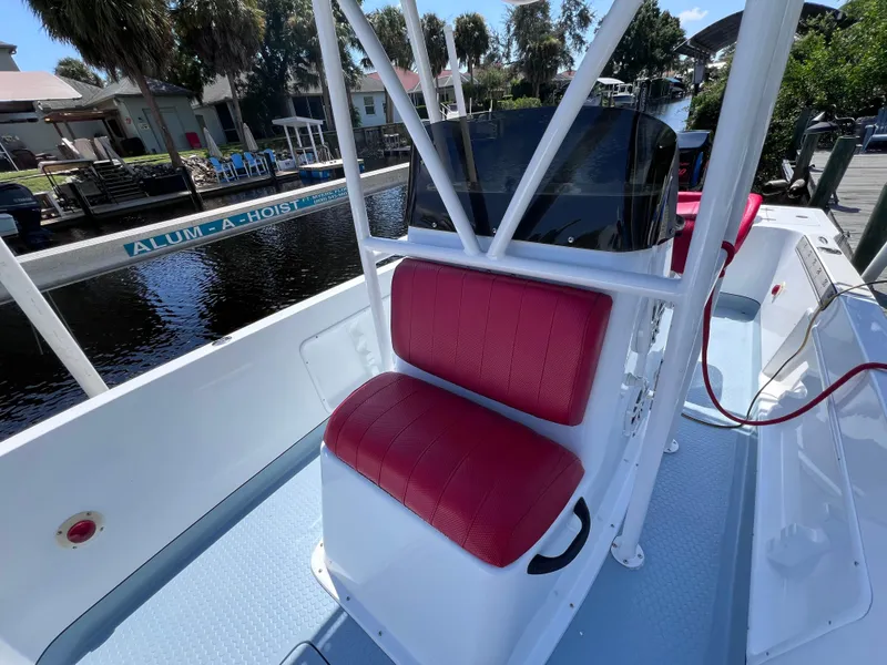 Slide: The Image of Red cushioned seat on Concept 23 boat, docked near waterfront homes, 2000 model. - 27