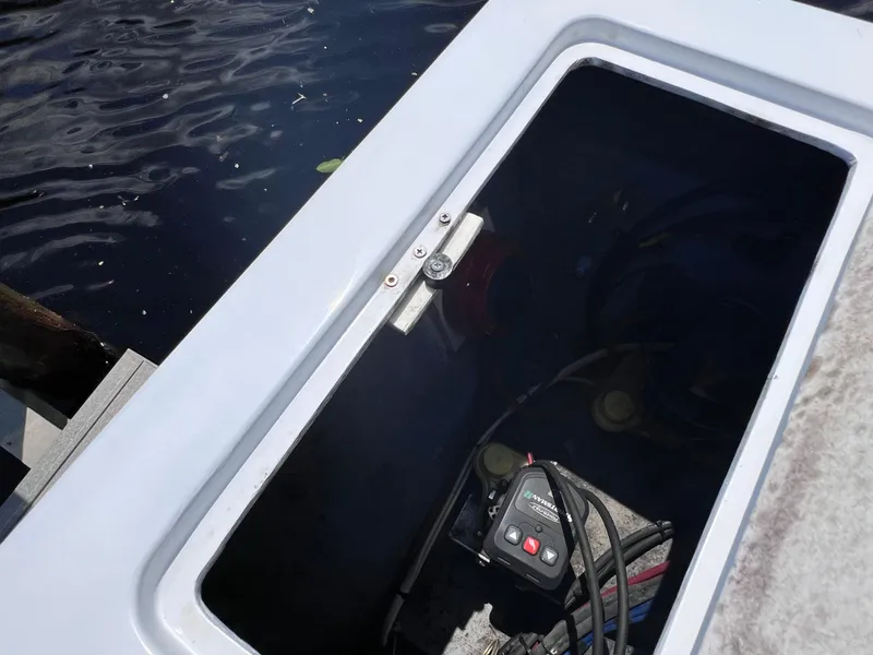 Slide: The Image of Open hatch on Concept 23 boat, revealing interior components, dockside view, 2000 model. - 31