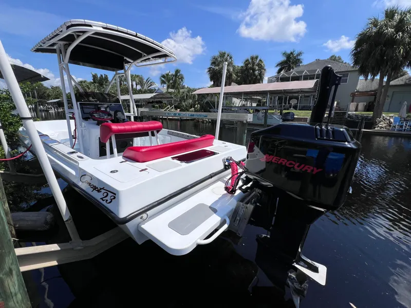 Slide: The Image of Boat docked on a canal, Concept 23 model, featuring a Mercury outboard motor. - 7