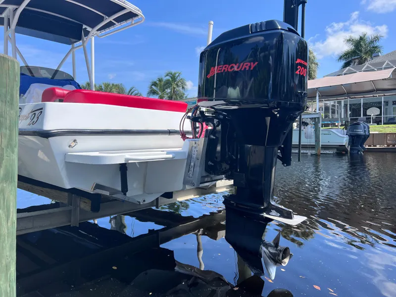 Slide: The Image of Boat with Mercury 200 outboard motor, Concept 23 model, docked by waterfront. - 8