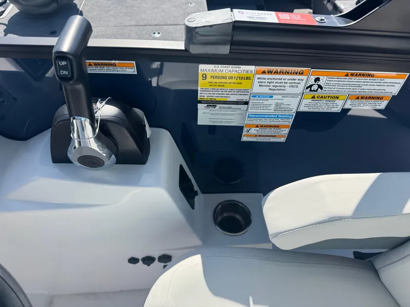 Slide: The Image of 2026 Hurricane FunDeck 1960 RE OB boat controls with warning labels and cup holders. - 12