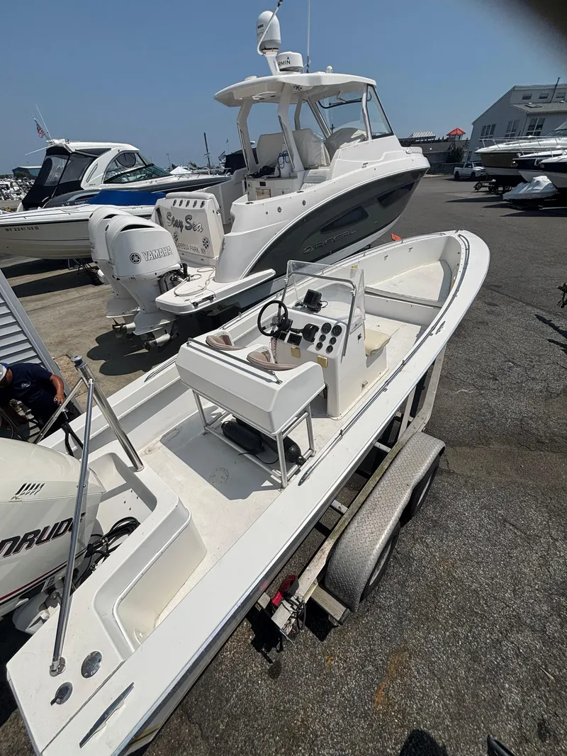 Slide: The Image of 1996 Superboat 24 on trailer, parked near other boats in a marina. - 10