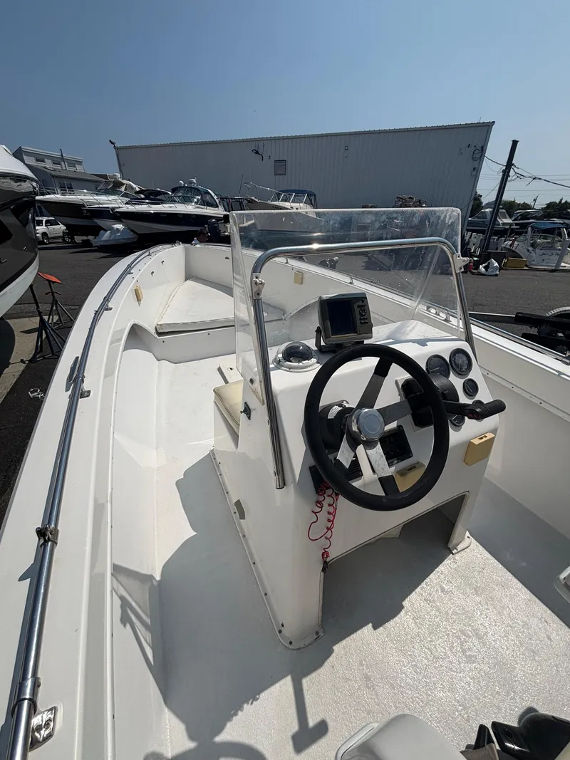 Slide: The Image of 1996 Superboat 24 cockpit with steering wheel and gauges, docked outdoors. - 11